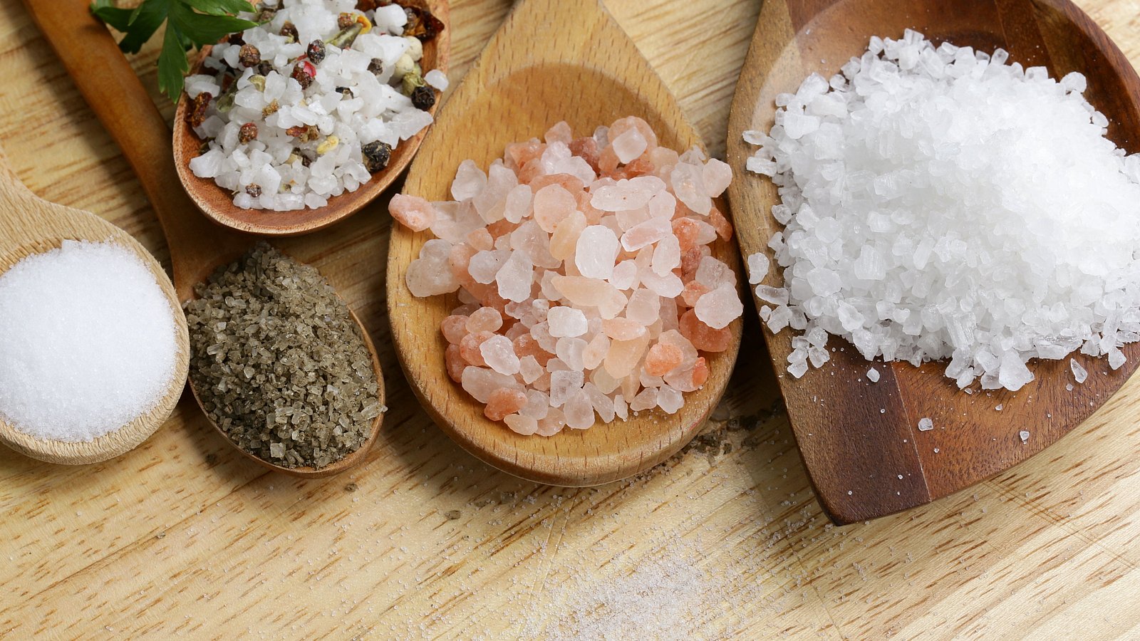 Verschiedene Salzsorten werden auf unterschiedlich großen Holzlöffeln präsentiert.
