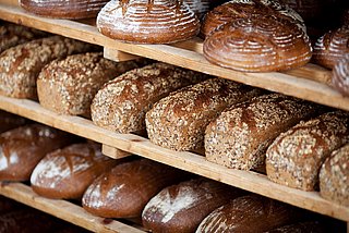 Mehrere verschieden Laibe Brot in einem Regal.